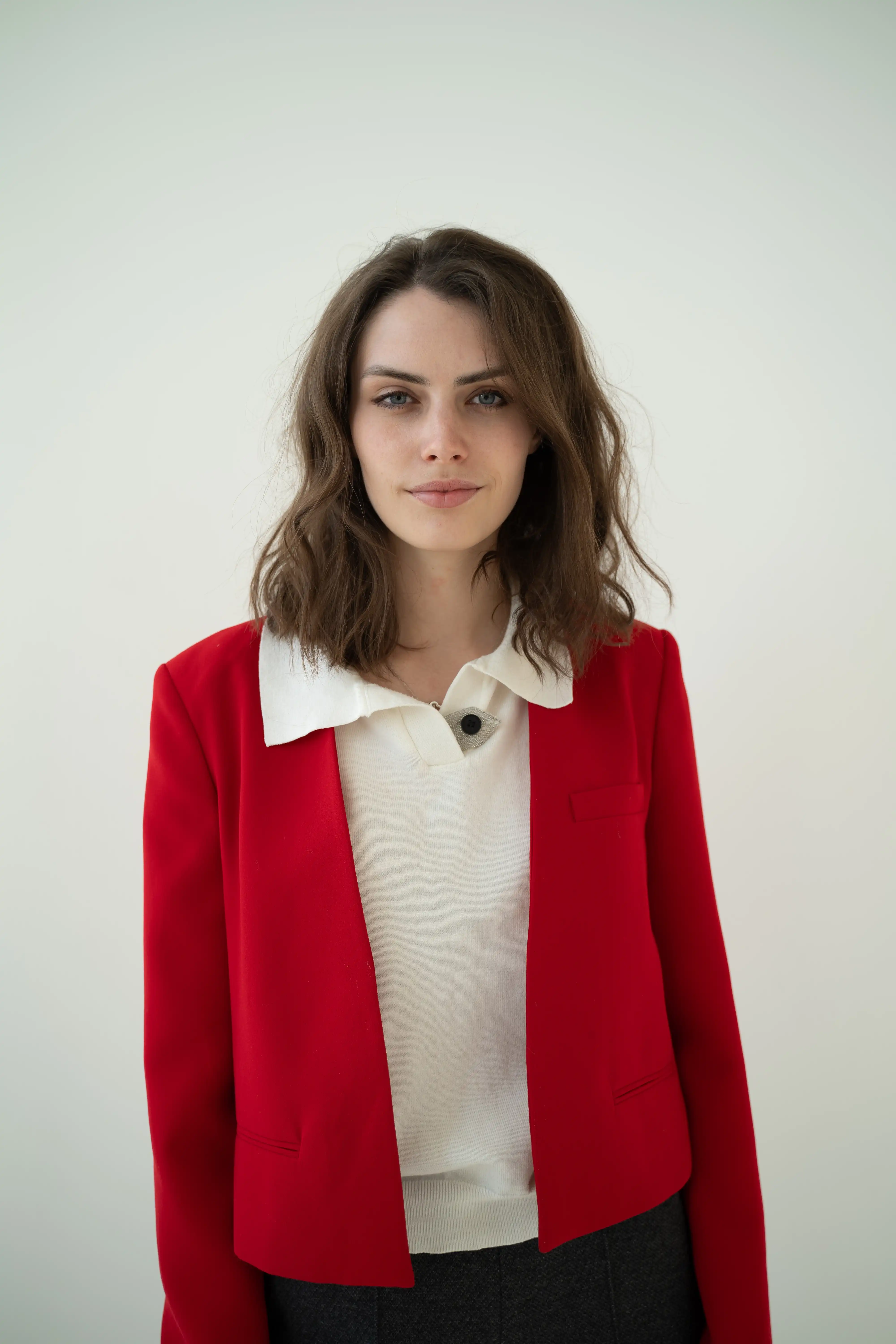 a young woman with brown hair wearing red blazer